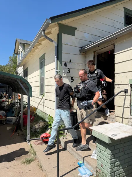 People standing on the front steps of a house.