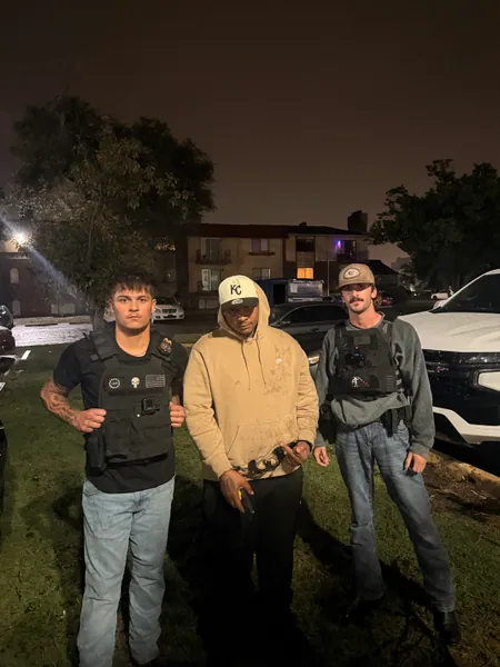 Three people standing outdoors at night.