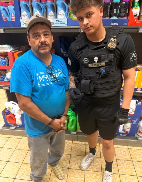 Two people standing inside a convenience store.