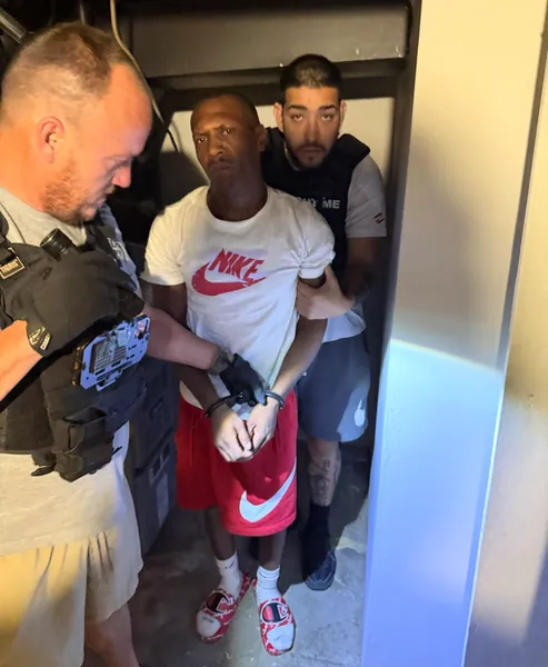 Three people gathered in a narrow interior doorway.