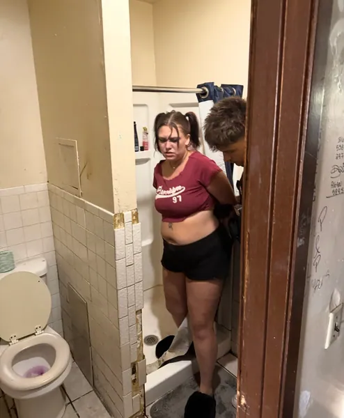 People visible through an open bathroom doorway.
