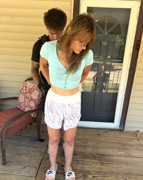 Two people standing on a wooden porch.